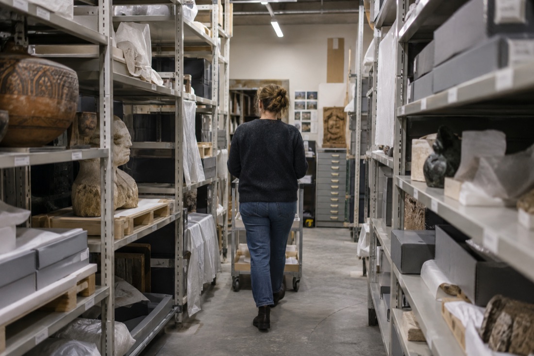A person walks between shelves in a museum collection store